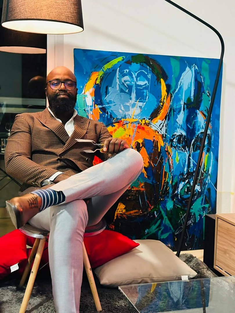 Jean-Marc OttiOné assis devant une œuvre bleue